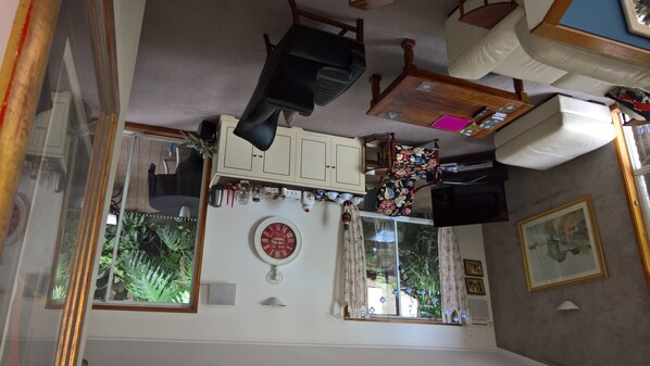A room with a dining table, chairs, a clock, and a window with curtains. - Linley House (Linley Point)