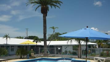 Relax by the pool surrounded by lush greenery and comfortable lounge chairs.