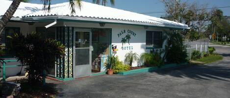 A Palm Court Motel with a white exterior, palm trees, and a signboard.