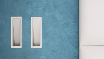 A blue textured wall with two white rectangular vents.