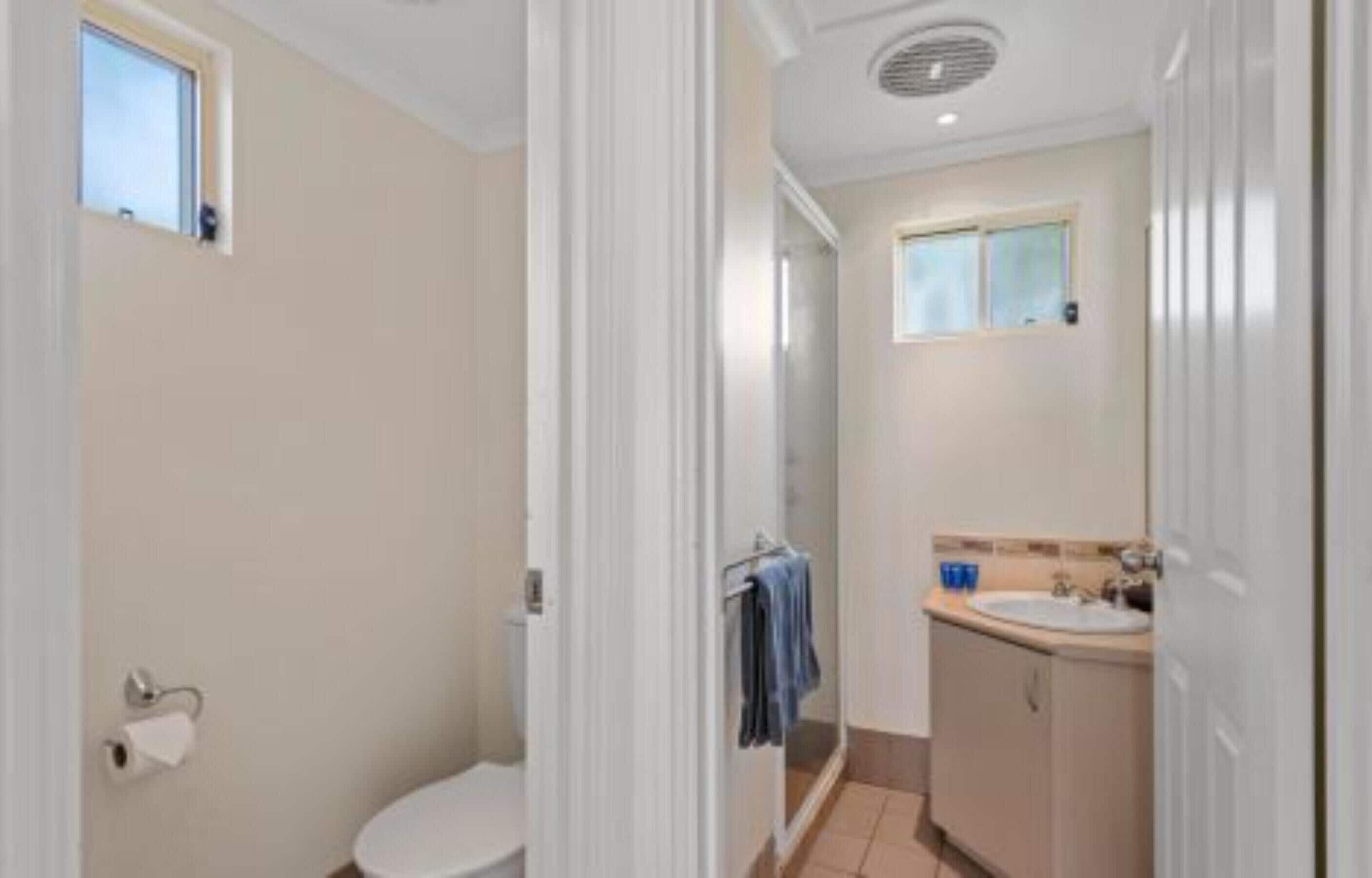 Une salle de bain avec des toilettes, une douche et un lavabo.