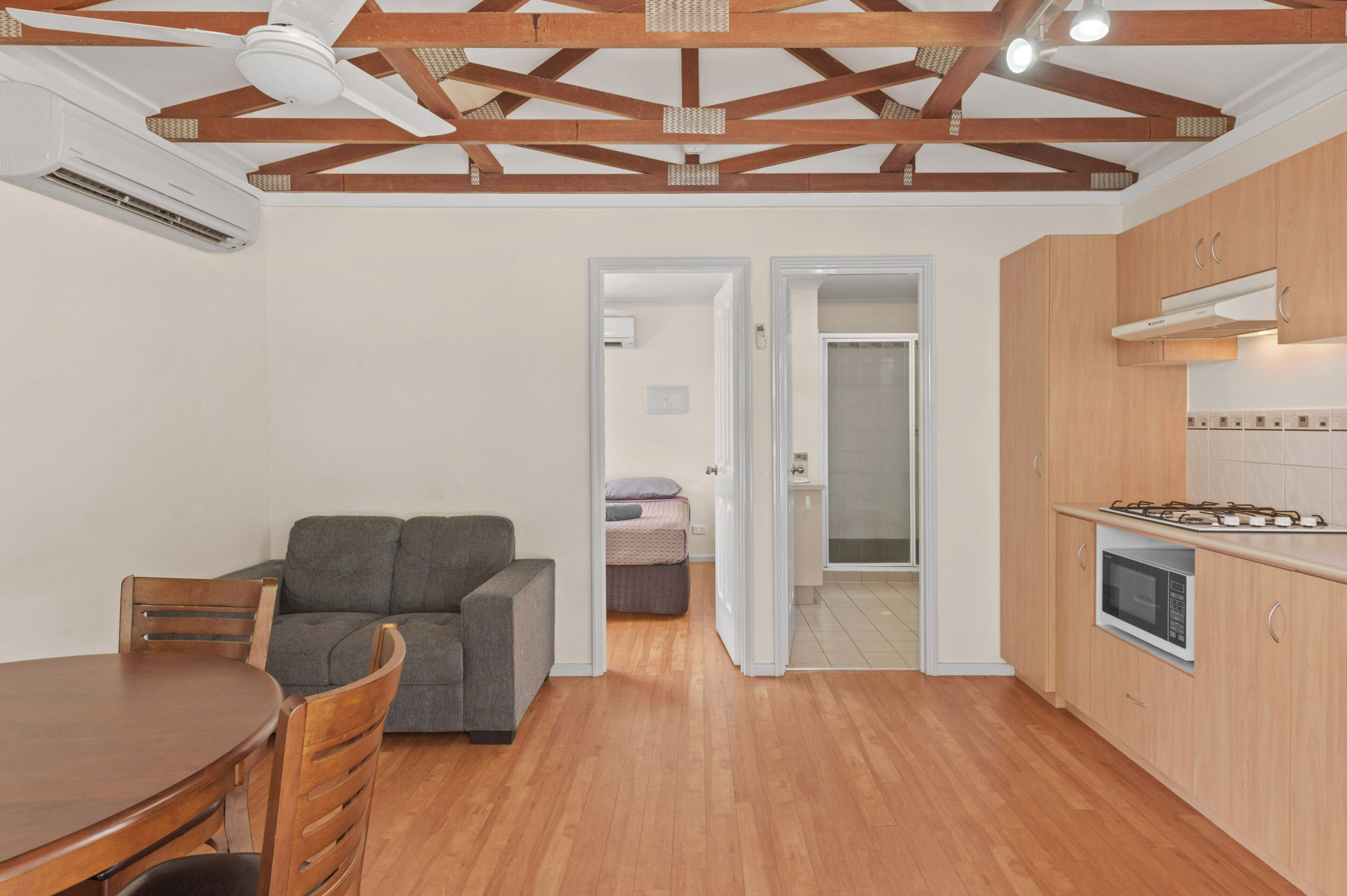 A modern kitchen with wooden cabinets, a built-in microwave, and a gas stove.