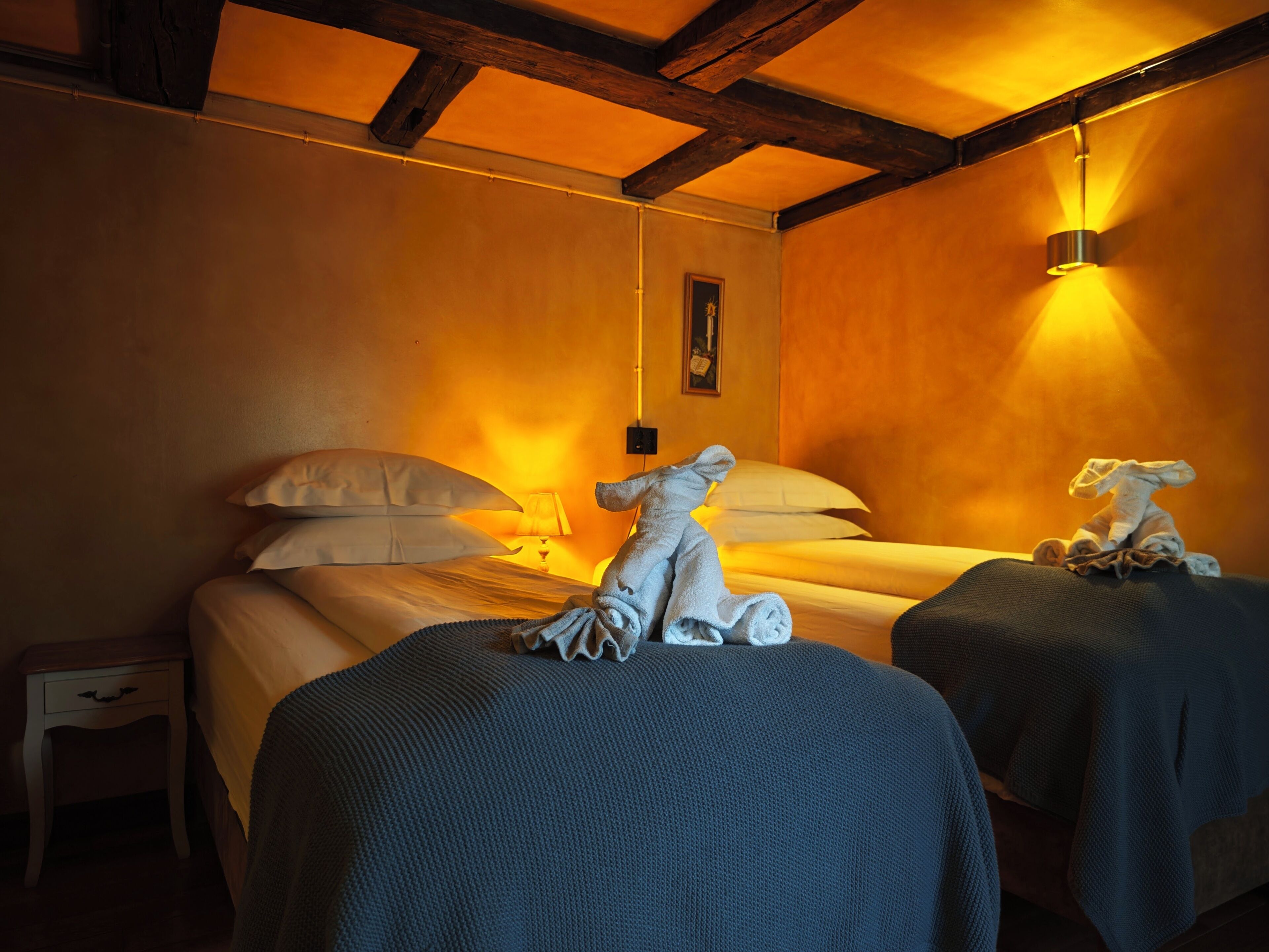 Une chambre d’hôtel avec deux lits, chacun étant équipé d’une serviette et d’une lampe.