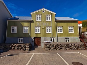 Ein grünes Gebäude mit einem Schild, auf dem 'Hotel Tidastöll' steht.