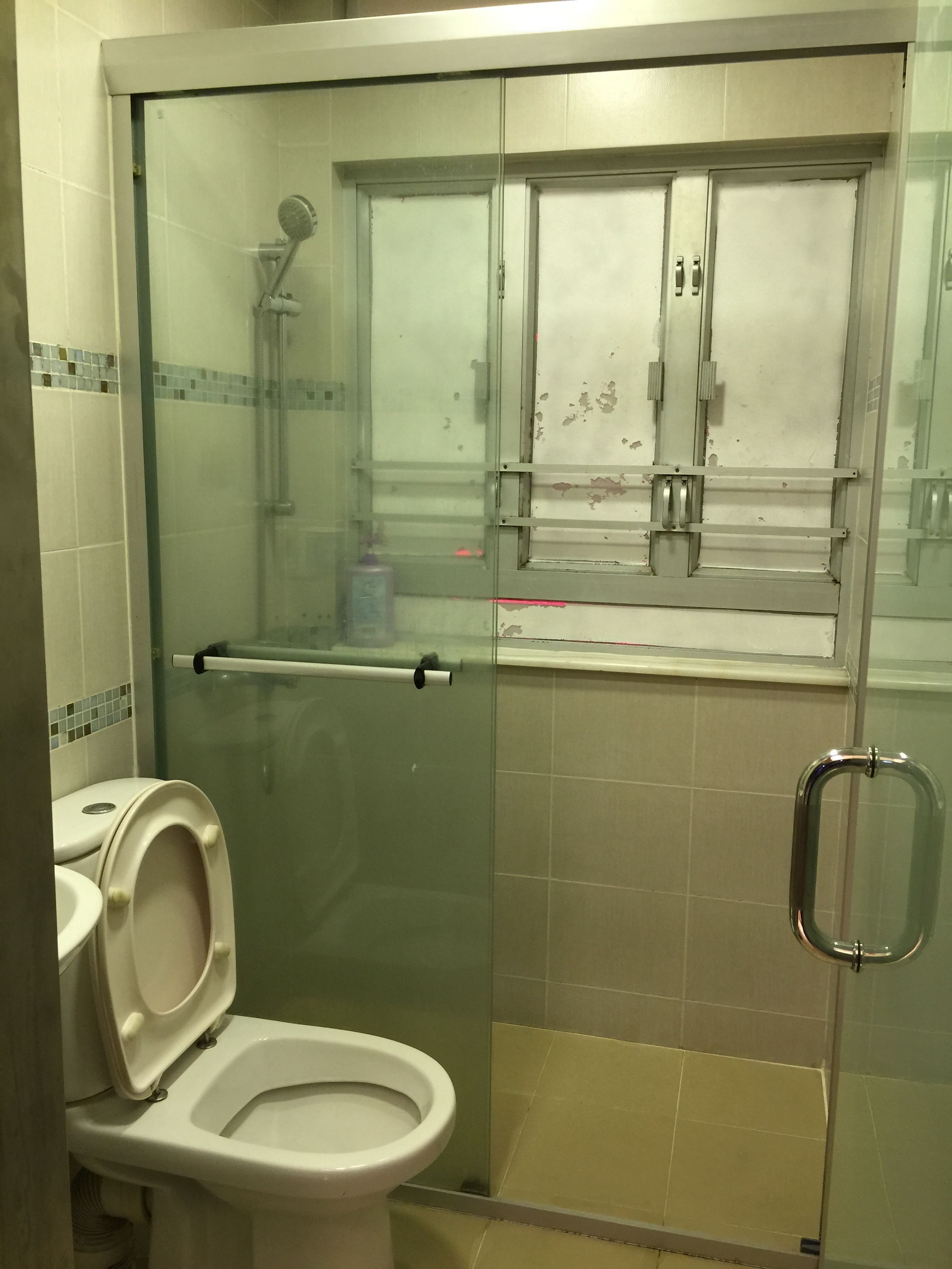 A small bathroom with a glass-enclosed shower, a toilet, and a sink.