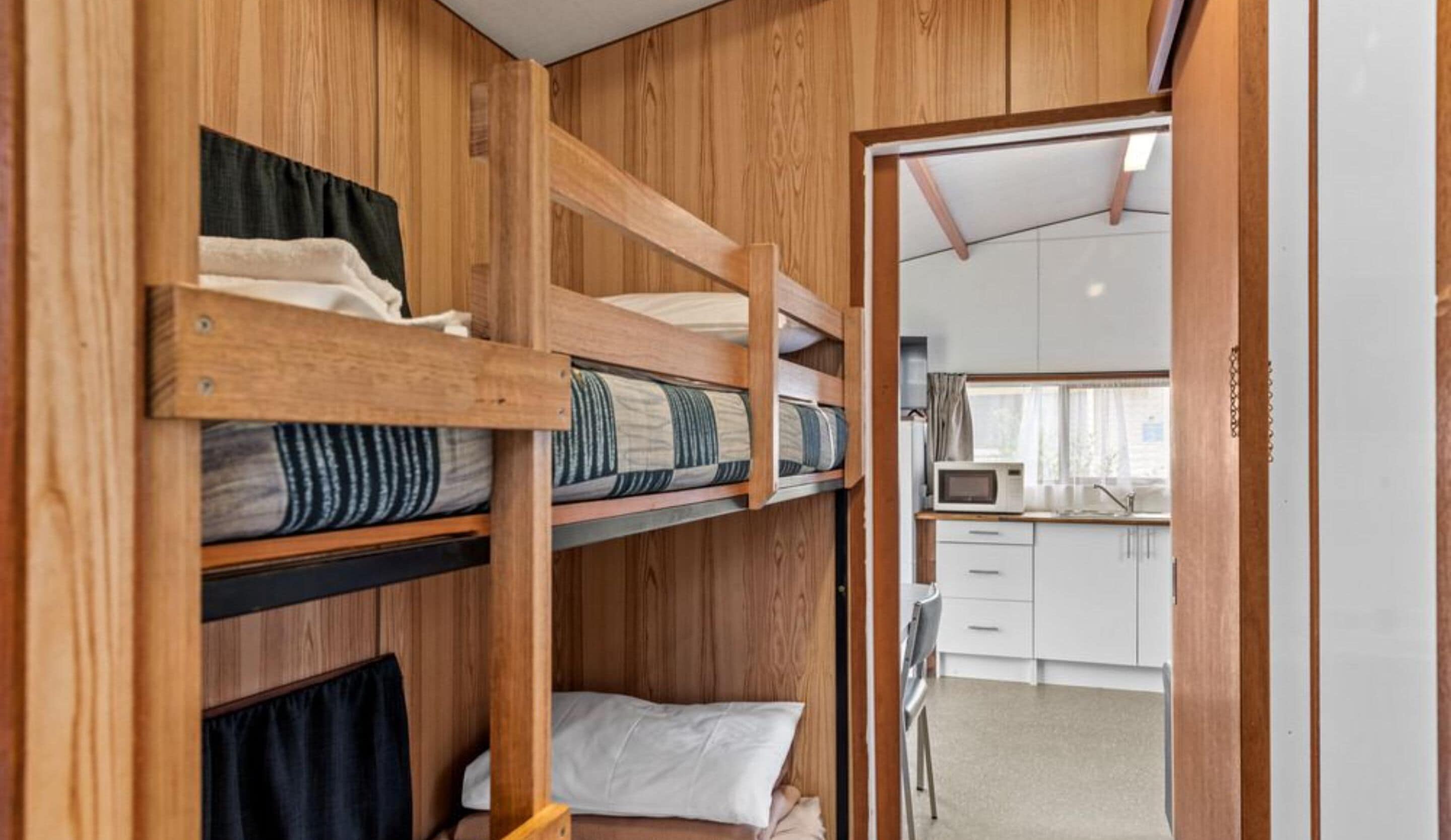 A compact room with bunk beds and a kitchenette.