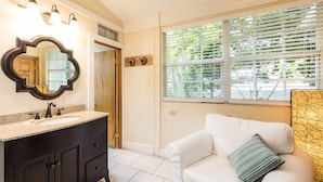 A bathroom with a vanity, a mirror, and a window with blinds. - L'Habitation Guest House - Adults Only (Key West)