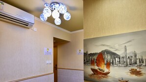 A hotel hallway with a ceiling fan, a painting of a sailboat, and a door leading to another room. - Wonderful Inn (Kowloon)