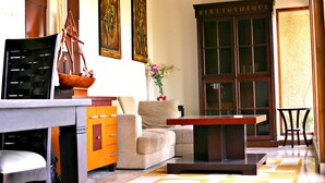 A well-lit living room with a sofa, coffee table, and a bookshelf labeled 'BIBLIOTHÈQUE'. - De Bukit Dago Villa by HouseinBandung (Bandung)