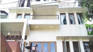 A multi-story residential building with a balcony and a staircase leading to the entrance. - De Bukit Dago Villa by HouseinBandung (Bandung)