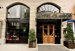 The exterior of HotelClasico with a classic facade, large arched windows, and a prominent entrance. - Hotel Clasico (Buenos Aires)