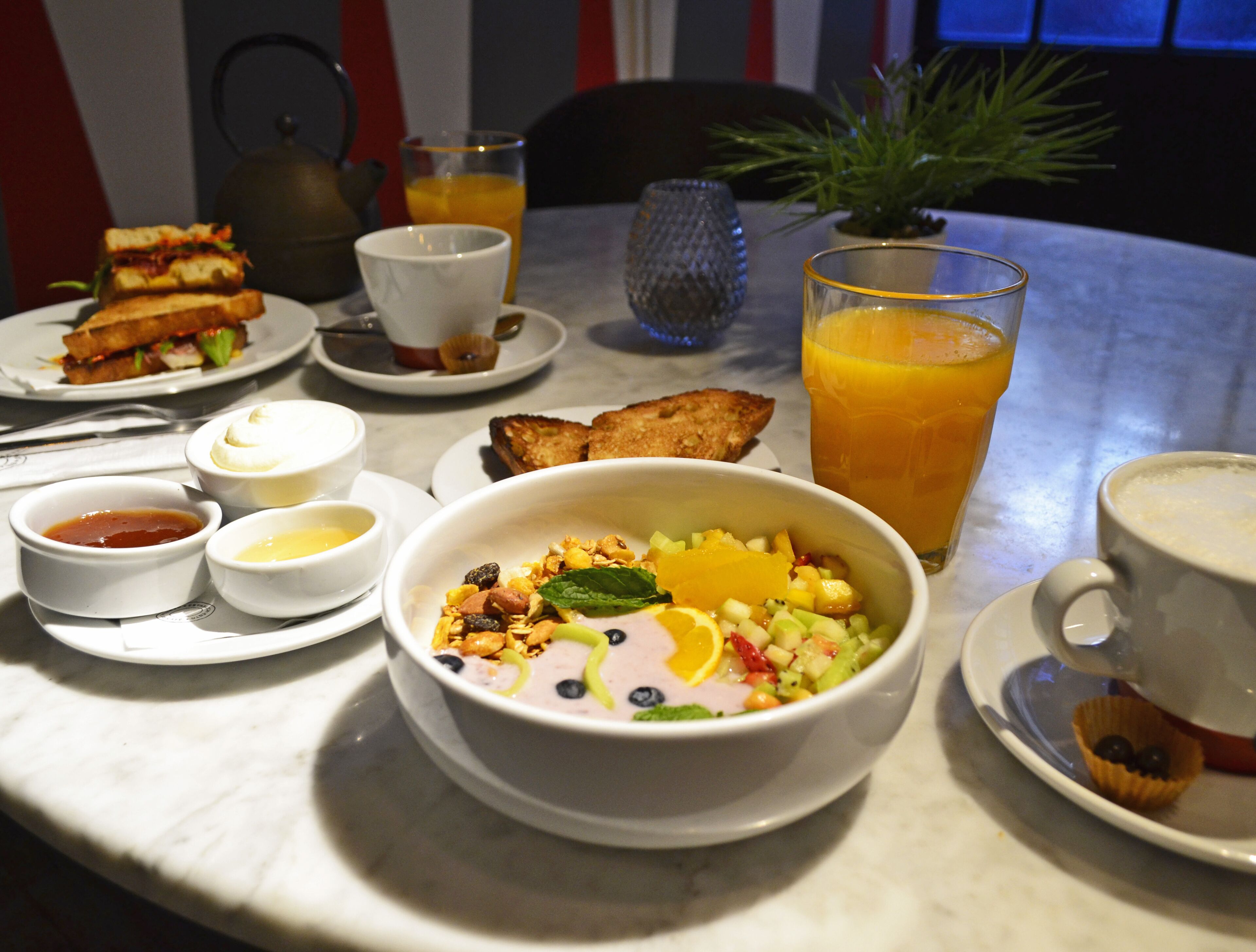 A breakfast setting with a bowl of cereal, toast, and a glass of orange juice on a table.