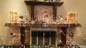 A fireplace with decorative lights and flowers. - Balsam Suites Boutique Inn & Residence (Timmins)