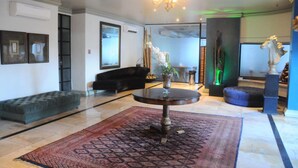 Un vestíbulo amplio con una mesa redonda, un sofá y un jarrón decorativo.