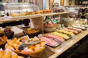 A buffet with various food items including bread, meats, cheeses, and fruits. - Gallant Hotel (Rio de Janeiro)