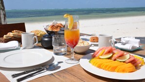 A breakfast table with a view of the beach and ocean. - Indigo Beach Zanzibar (Bwejuu)