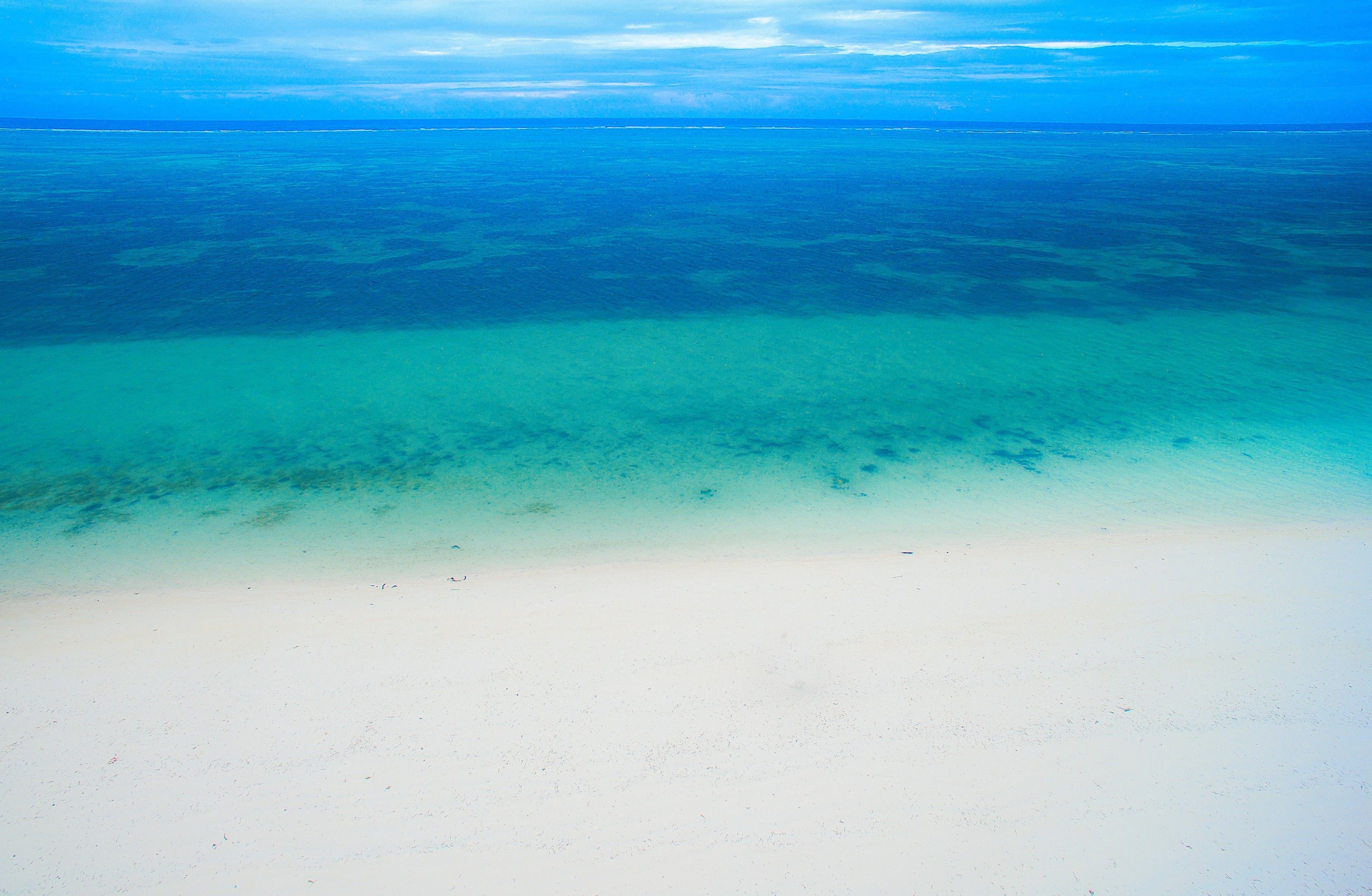 Una playa con agua turquesa cristalina y arena blanca.