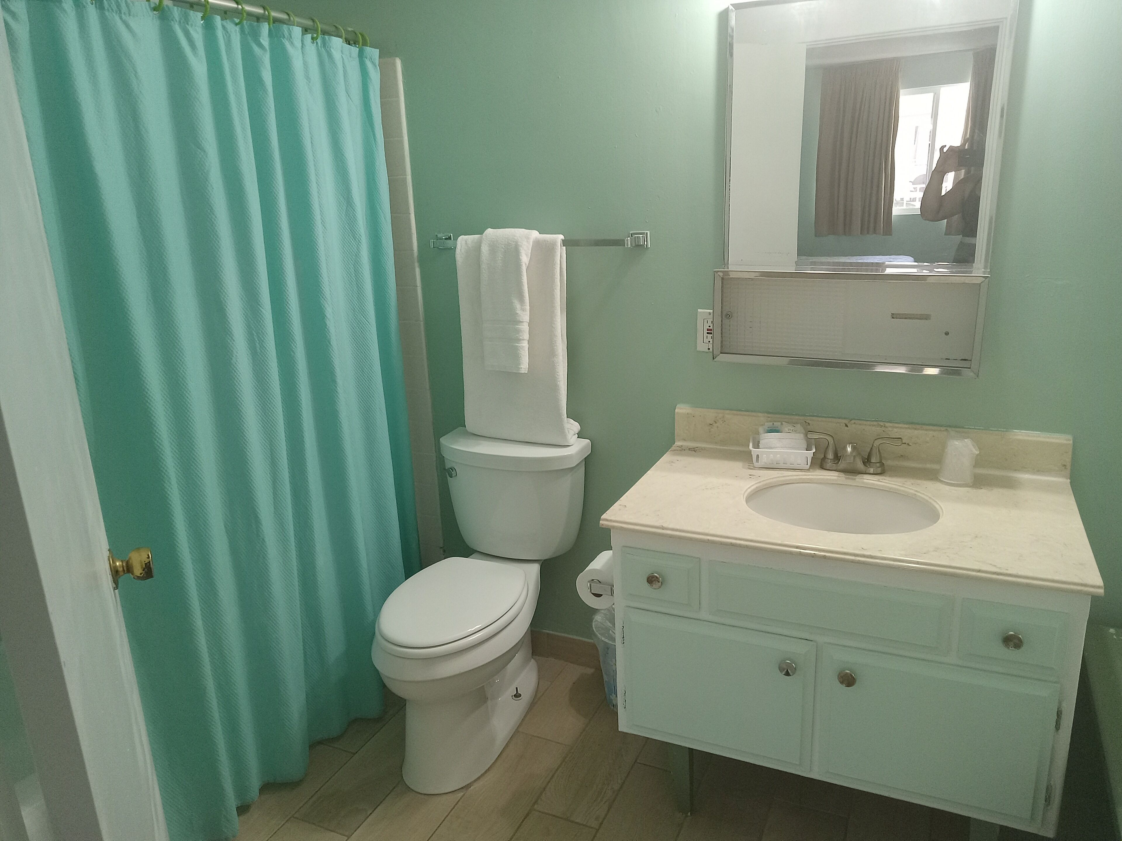 Ein Badezimmer mit Toilette, Waschbecken und Spiegel.
