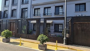 Un immeuble à plusieurs étages, de style architectural classique, doté de grandes fenêtres et d’une entrée protégée par un portail.