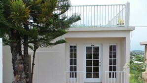 A building with a white exterior, a balcony with white railings, and a door labeled "Office".