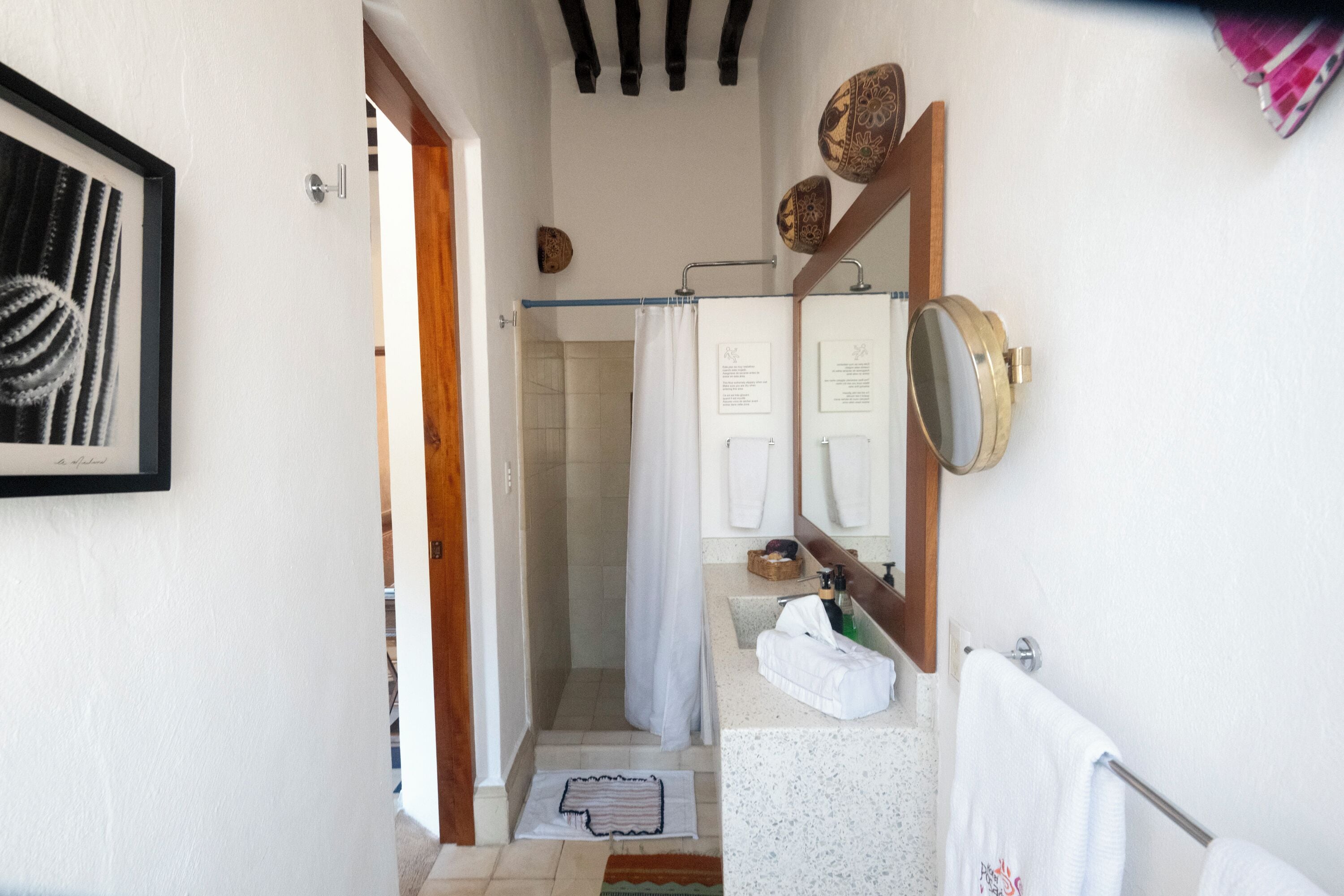 Un baño con ducha, lavamanos y espejo.