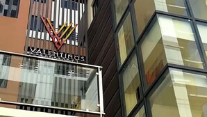 A modern building with a glass facade and a sign for 'Valentinos'.