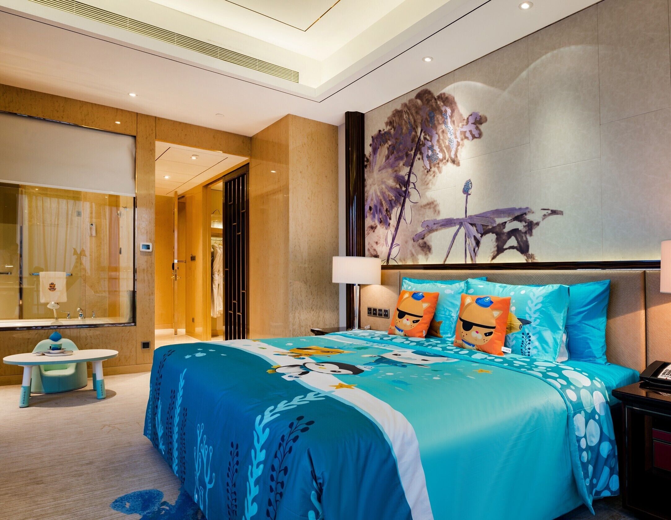 Une chambre d’hôtel moderne avec un grand lit, un tableau au mur et une vue sur la salle de bain.