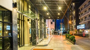 A modern hotel entrance with a glass facade, marble columns, and a covered walkway. - Sea Me Spring Hotel (Pattaya)