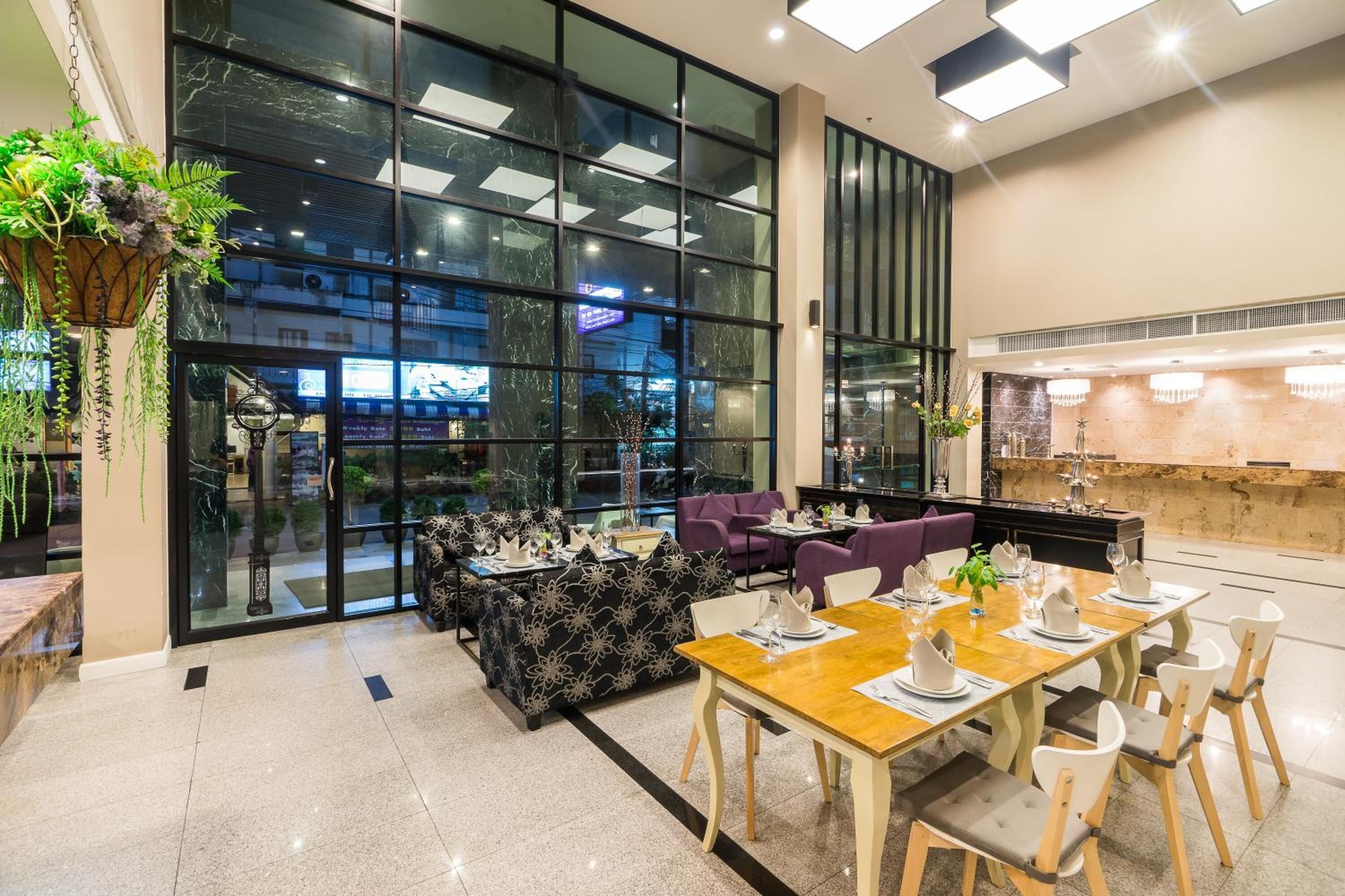A modern restaurant with a glass wall, black and white patterned seating, and a wooden dining table.