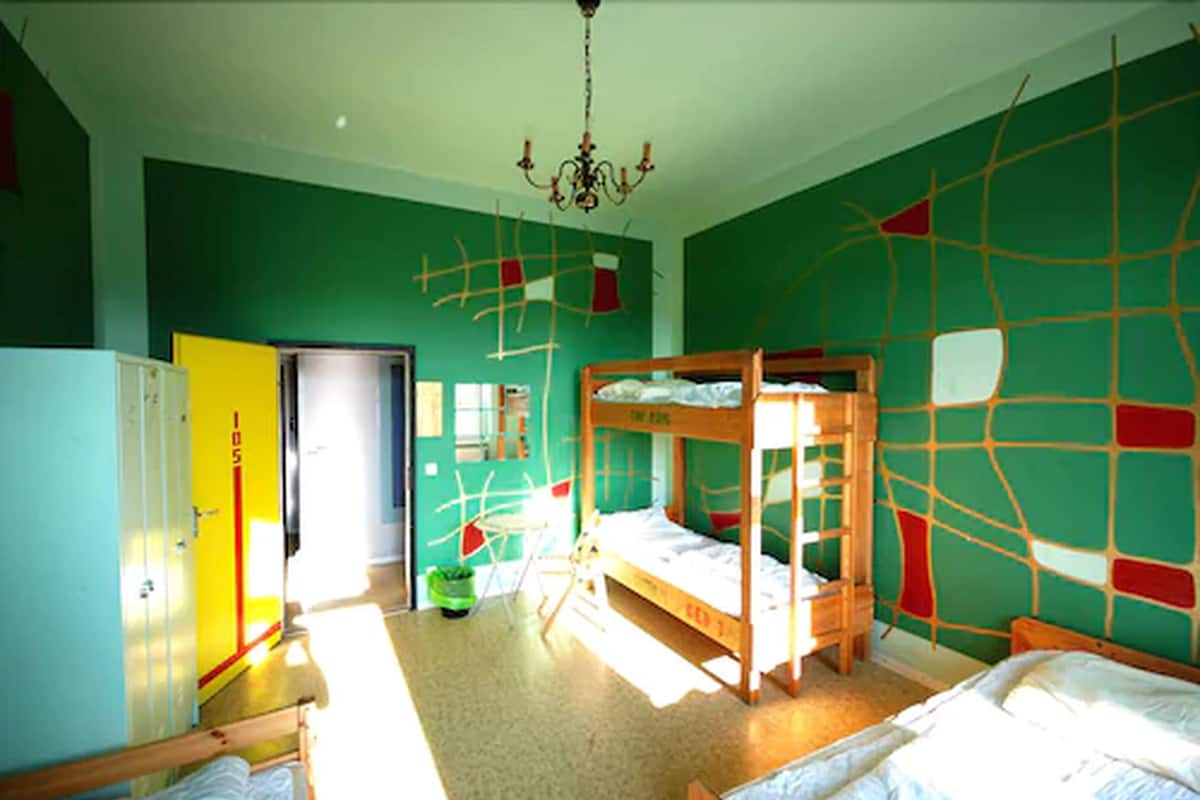 Una habitación con literas, un candelabro y una puerta con un número.