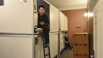 Habitación de hotel pequeña con kitchenette, una zona de estar reducida y una puerta con el número 6.