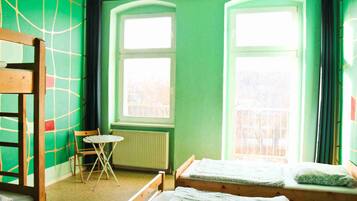 Una habitación con dos camas, una silla y un radiador.