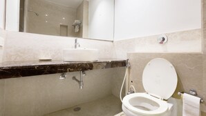 A modern bathroom with a marble countertop, a sink, a toilet, and a shower. - OYO Rooms Cyber City (Gurugram)