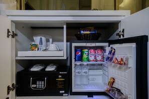 A minibar with a coffee maker, a microwave, and various snacks and beverages. - J8 Hotel (Singapore)