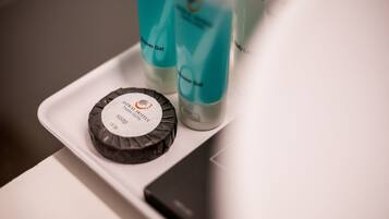 A tray with a black soap bar and two bottles of body lotion.