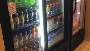 A beverage refrigerator stocked with various drinks including Mountain Dew, Pepsi, and other sodas. - Travelodge by Wyndham Steele (Steele)
