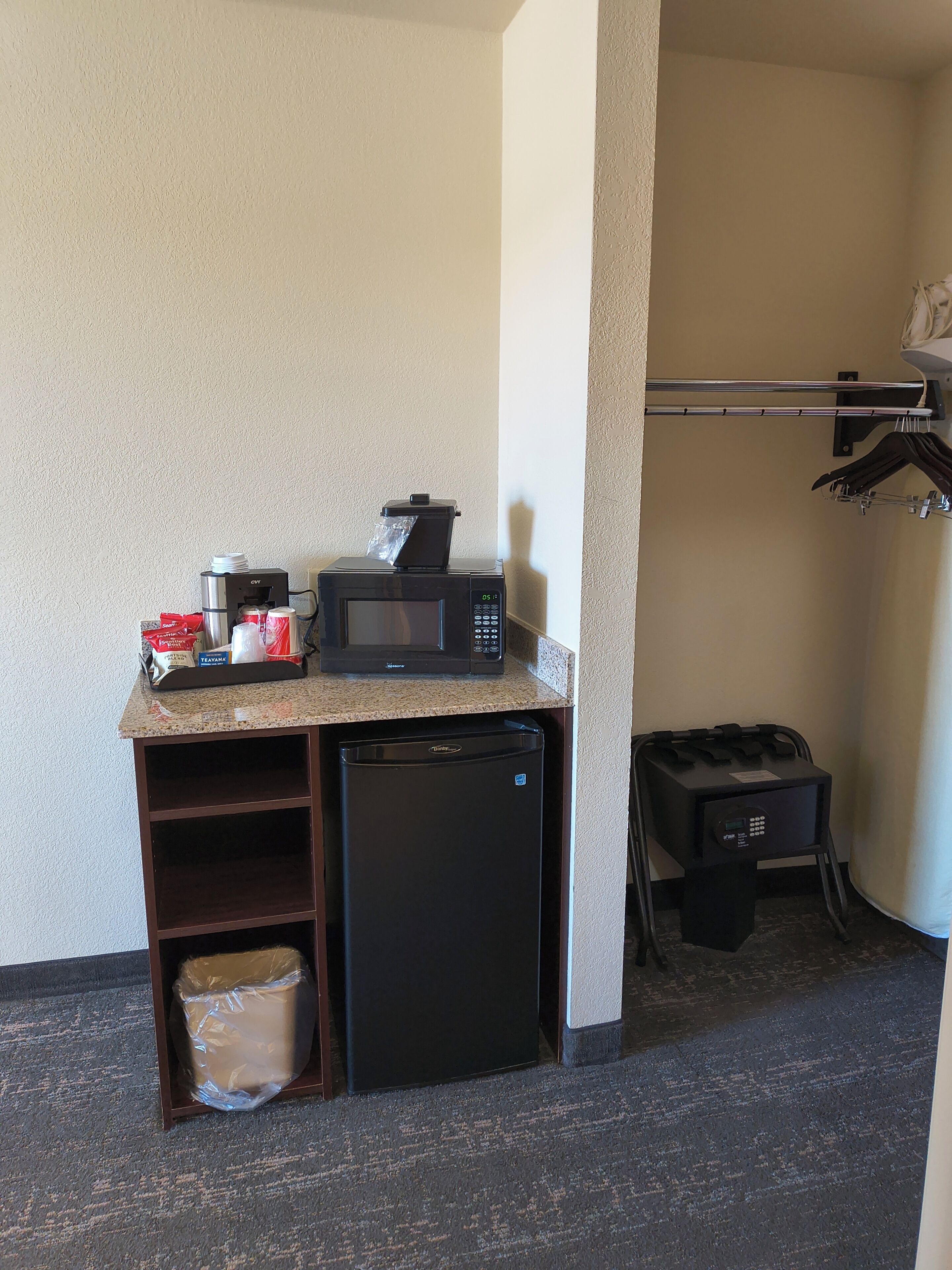 A kitchenette with a microwave, refrigerator, and a small sink.