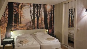 A bedroom with a large bed, a desk, and a wardrobe. - Hotel Arcense Herberg (Arcen)