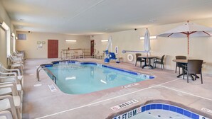 Una piscina con sillones de descanso y un área de hidromasaje.