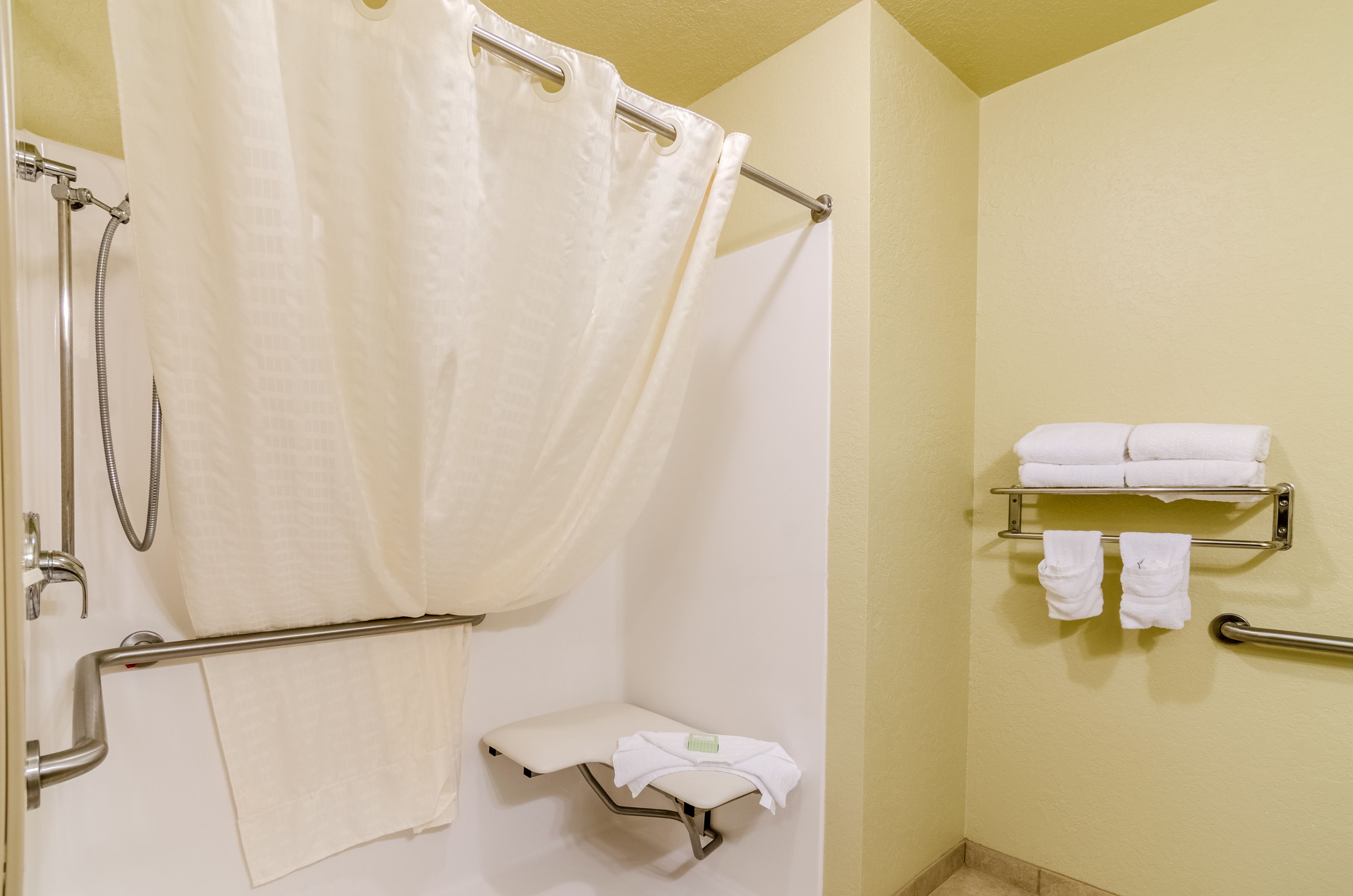 Un bany amb dutxa, vàter i paraigua per a tovalloles.