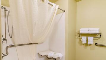 A bathroom with a shower, a toilet, and a towel rack.