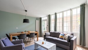 Una sala de estar con sofá, sillas, una mesa de centro y una mesa de comedor.