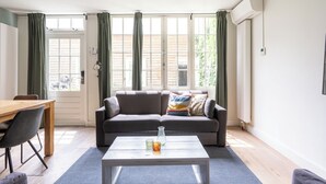 Una sala de estar con un sofá, una mesa de centro y un comedor con mesa y sillas.