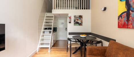 A modern living space with a staircase, a dining area, and a sofa.