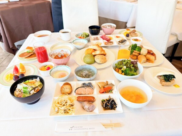 A table set with various dishes, including sushi, pasta, and a soup bowl.