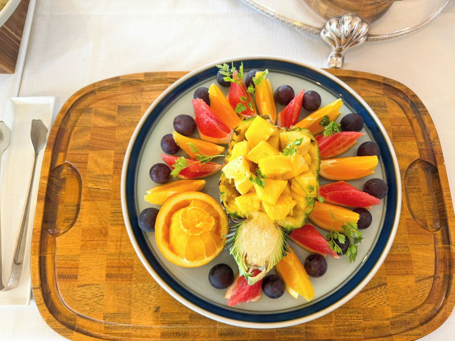 A fruit platter on a plate with a wooden tray.