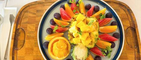 A fruit platter on a plate with a wooden tray.