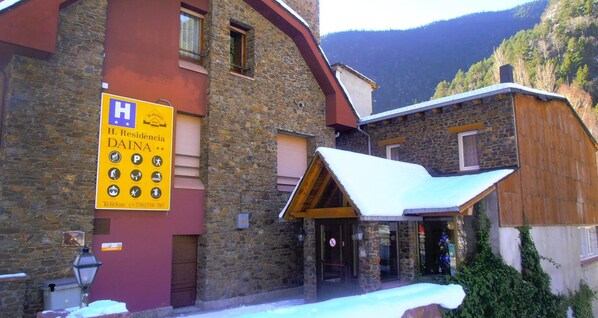 A stone building with a yellow sign indicating a hotel named H. Residencia Daina. - Residencia Daina (Arinsal)