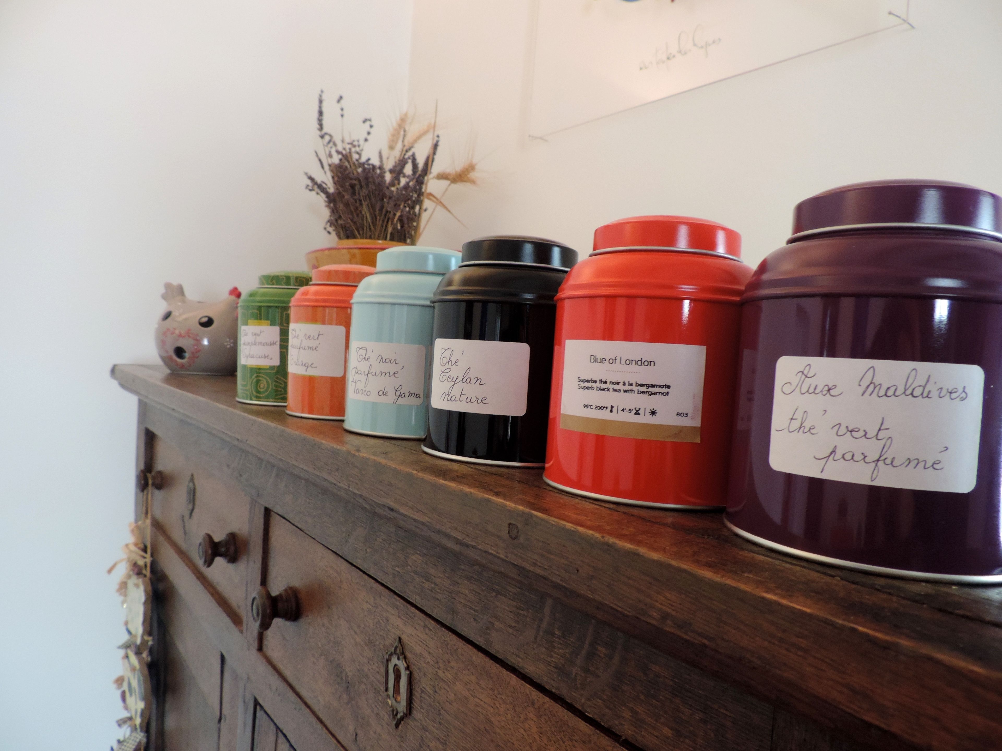 A wooden shelf with various scented candles and a decorative ceramic pig.