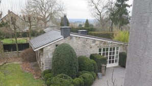 A stone house with a chimney, a large window, and a well-maintained garden. - La Buissonnière (Ferrieres)